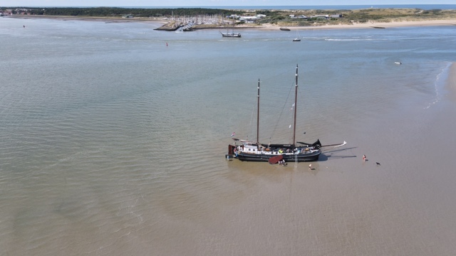The tjalk Aagtje has fallen dry on a sandbank in the Wadden Sea