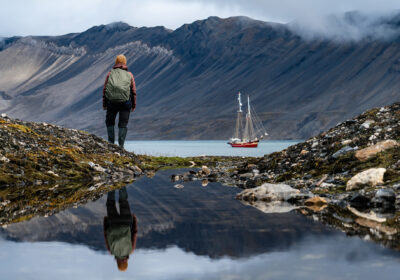 Noorderlicht anchored with guest hiking Svalbard Summer