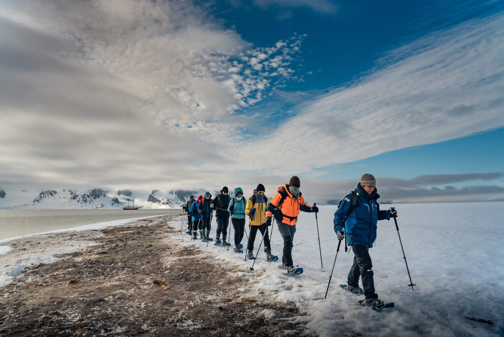Guests walk across a glacier in Svalbard