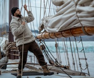 Noorderlicht Guest pulling ropes onboard tall ship Svalbard